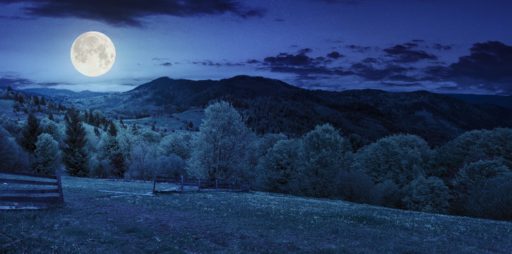 fence on hillside meadow in mountain at night