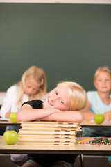 Mädchen auf Bücherstapel in der Grundschule