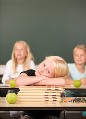 Mädchen auf Bücherstapel in der Grundschule