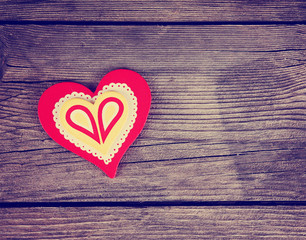 a valentine's day heart on a wooden background toned with a retro filter