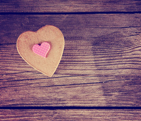 a valentine's day heart on a wooden background toned with a retro filter