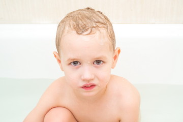 Little boy with wet soapy head isolated on white background