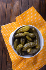 Marinated cucumbers on wooden background
