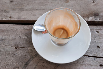 Empty glass cup of coffee latte on wooden table.
