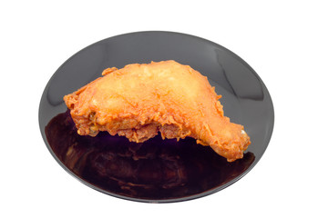 Fried chicken legs on black dish