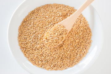 Gold flax seeds on a wooden spoon