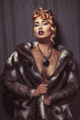 Fashionable blonde woman with make up looking at camera in fur c