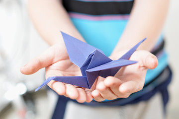 Origami crane in children's hands