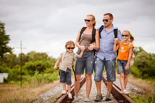 Happy family walking on the railway at the day time.