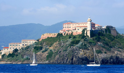 Fototapeta na wymiar Sailboat cruising in front of Portoferraio on Elba island
