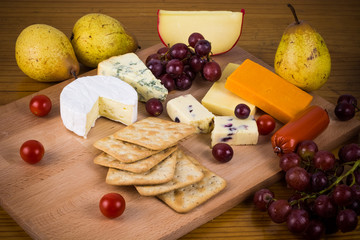 Delicious cheese platter with grapes and crackers