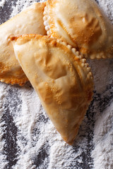 empanadas on a background of flour close-up. vertical top view