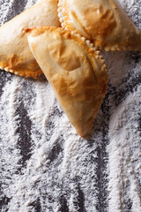 empanadas on a table with flour spills. vertical top view