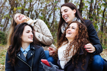 Group of friends with a smartphone, talking and laughing