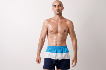 Fototapeta premium Fit bodybuilder showing his body.Muscular topless man in shorts.