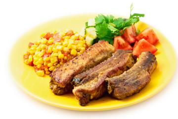 The pork chops with roasted corn on the yellow plate