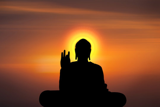silhouette of buddha and sunset background with blur motion