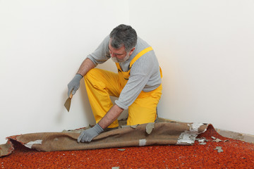 Home renovation, worker remove carpet from room floor