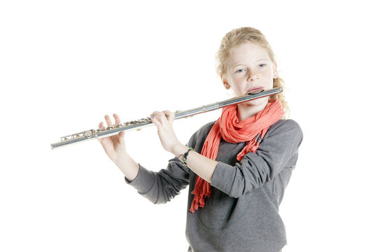 young girl with red hair and freckles plays flute