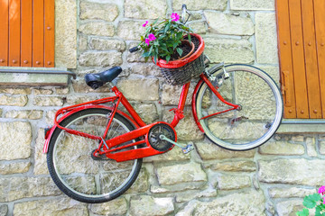 Fototapeta na wymiar Bicycle on a wall with flowers in a basket