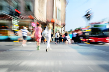 Zoom and motion blurred crowd crossing street