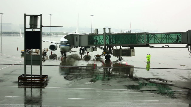 passengers walking on boarding bridge at airport jetway