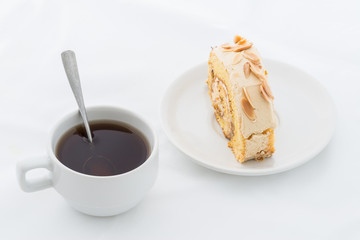 Almond roll cake on white dish with hot drink