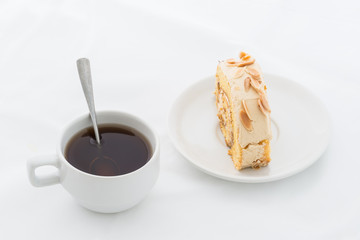 Almond roll cake on white dish with hot drink
