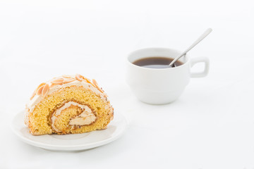 Fototapeta na wymiar Almond roll cake on white dish with hot drink