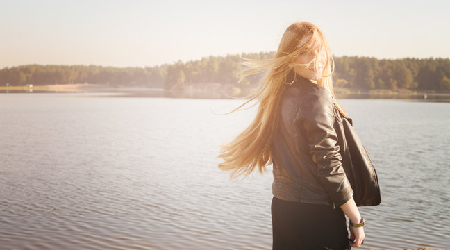 unusual Gothic girl with long red hair reflects at lake