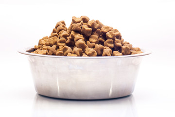 Isolated metal bowl with dog dry food.