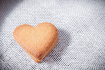 Obraz na płótnie Canvas Butter cookies, heart shaped, on a white fabric napkin