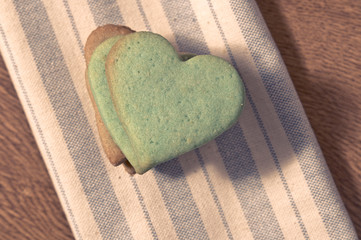 Green butter cookies, heart shaped,  on a striped fabric napkin
