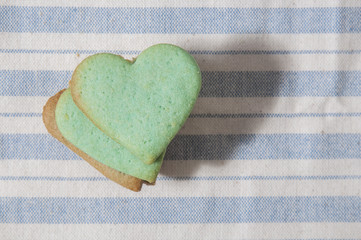 Green butter cookies, heart shaped,  on a striped fabric napkin