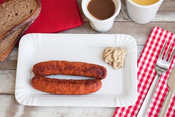Bratwurst with mustard for breakfast, with drinks, top view