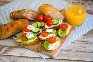 Fototapeta na wymiar Small tasty bites for breakfast on wooden table