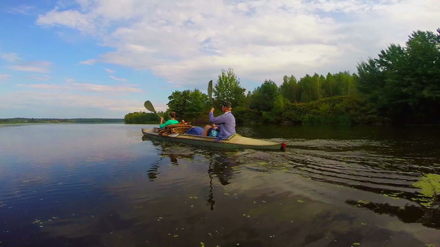 Couple of tourists paddling kayak down the river, slow motion