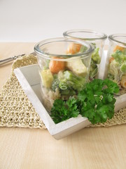 Fisch und Gemüse auf Reis im Glas