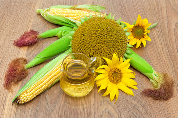 mature sunflowers, corn and oil in a glass jar close-up on woode