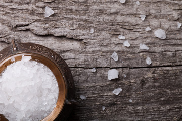 sea salt in an old utensils on wooden table