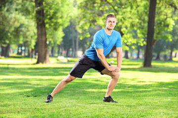 Obraz premium Full length portrait of a young smiling athlete exercising