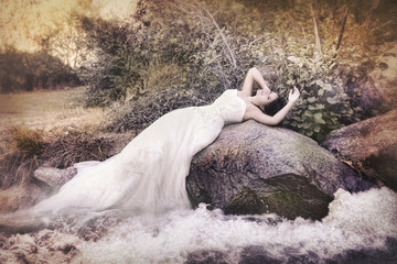 Bride with long gown near waters...