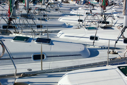 interlocking bows of a row of tightly moored sailing boats