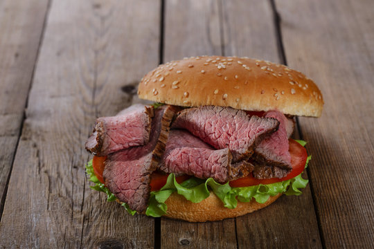 roast beef hamburger sandwich on a wooden surface
