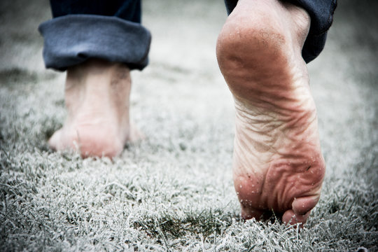 Barefoot walking on frosted grass