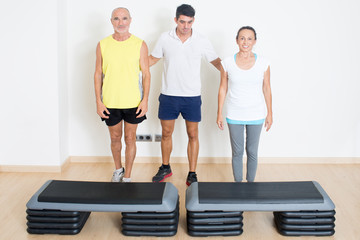 Trainer hilft Senioren beim step training
