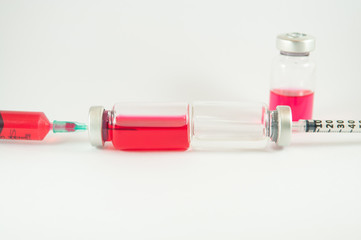 Red liquid in injection syringe and vials