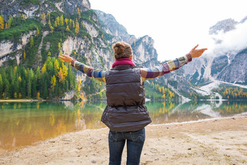Young woman on lake braies in south tyrol, italy rejoicing