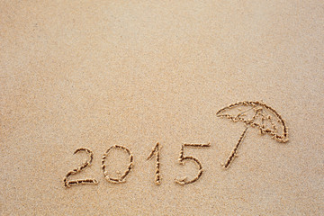 Inscription of the year 2015 written in the wet yellow beach san