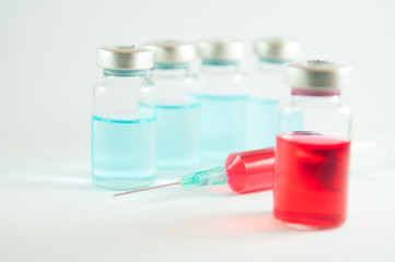Red liquid in injection syringe and vials